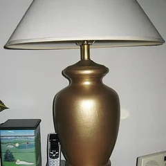 A table lamp with a brass urn-shaped base
