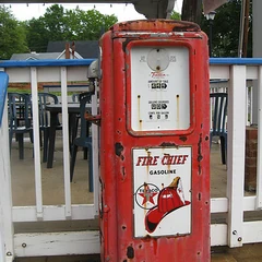 A red vintage gas pump with a round dial